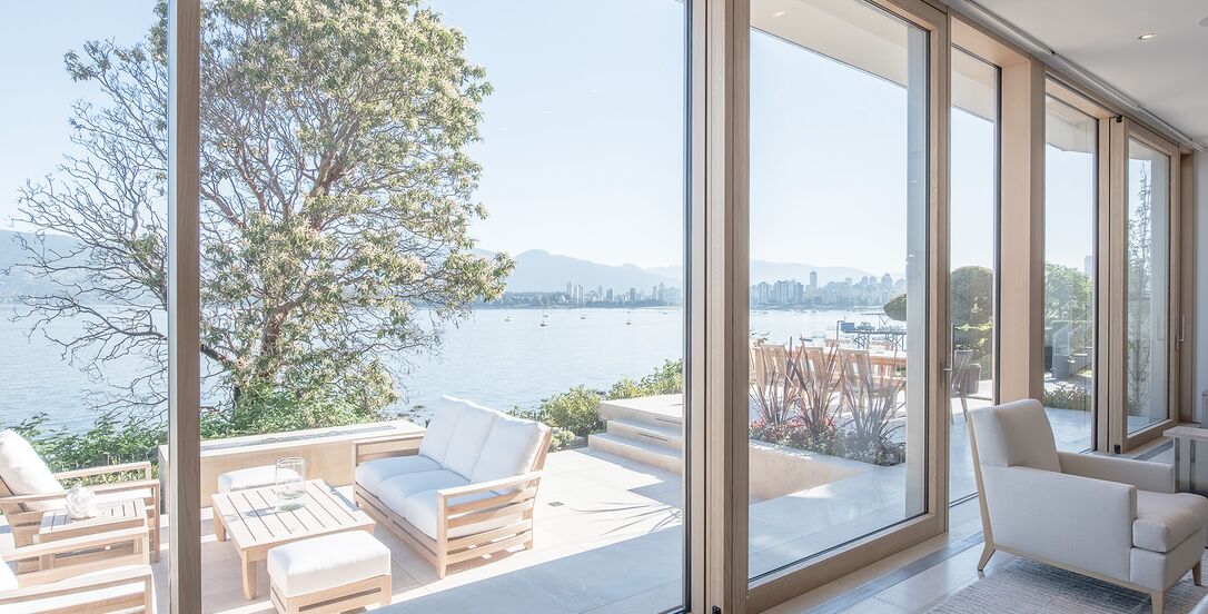 Blick auf Terrasse am See durch geöffnete UNILUX Holz-Alu Hebe-Schiebeanlage