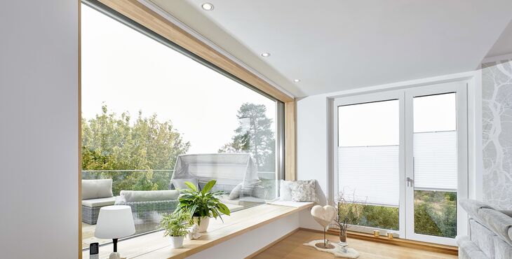 Wohnbereich mit großem Holzfenster Fenstern und Balkontür aus Holz