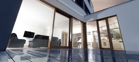 Blick von Terrasse ins Haus mit großem UNILUX Fensterelement aus Holz