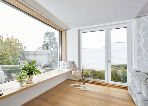 Wohnbereich mit großem Holzfenster Fenstern und Balkontür aus Holz