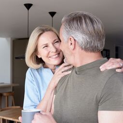 Best Age Frau umarmt Mann und lächelt