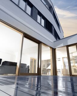 Blick von Balkon auf modernes Haus mit UNILUX FineLine Pfosten-Riegel-Fassade aus Holz und Alu