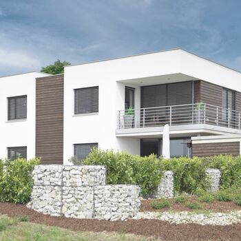 Mornes Wohnhaus im Bauhausstil mit UNILUX Holz-Alu Fenstern und Raffstore