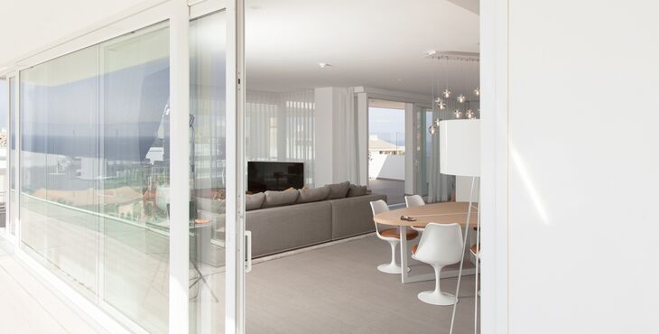 Blick vom Terrasse durch geöffnete UNILUX Kunststoff-Alu Hebe-Schiebe Anlage in modernen Wohnraum