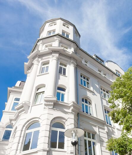 Fassade Stadtvilla mit UNILUX Holz Meisterfenster Denkmal vor blauem Himmel