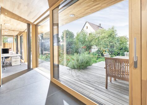 Innenansicht Bürogebäude mit eingeschossiger UNILUX FineLine Pfosten-Riegel-Fassade und Hebe-Schiebe-Element aus Holz und Alu