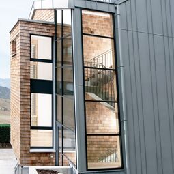 Außenansicht Treppenhaus mit UNILUX FineLine Pfosten-Riegel-Fassade aus Holz-Alu