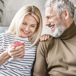 Glückliches Best-Age Paar sitzt auf Couch