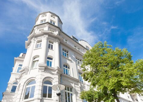 Fassade Stadtvilla mit UNILUX Holz Meisterfenster Denkmal vor blauem Himmel