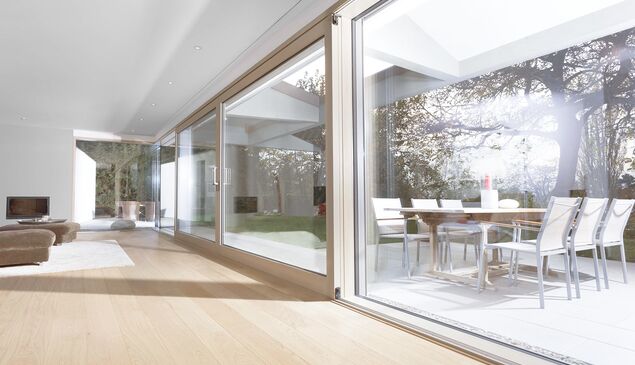 Großer moderner Wohnraum mit großer UNILUX Holz-Alu Hebe-Schiebe Anlage und Blick auf Terrasse