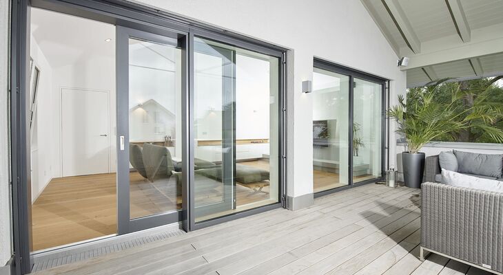 Blick vom Terrasse durch geöffnete UNILUX Kunststoff-Alu Hebe-Schiebe Anlage in modernen Wohnraum