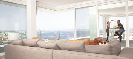 Wohnzimmer-Couch vor UNILUX Ganzglasecke OpenView