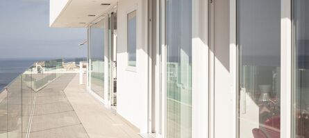 Blick auf sonnigen Balkon mit UNILUX Kunststoff Hebe-Schiebe-Anlagen