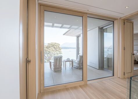 Blick aus Wohnraum auf Balkon durch geöffnete UNILUX Holz-Alu Hebe-Schiebe Anlage