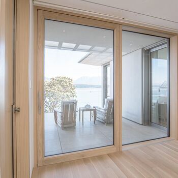 Blick aus Wohnraum auf Balkon durch geöffnete UNILUX Holz-Alu Hebe-Schiebe Anlage