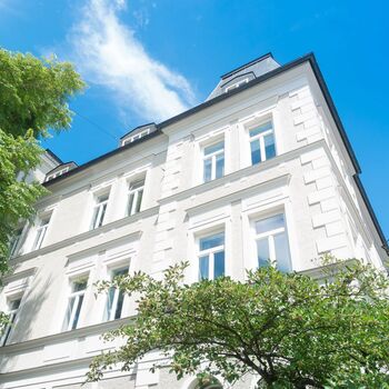 Fassade Stadtvilla mit UNILUX Holz Meisterfenster Denkmal vor blauem Himmel