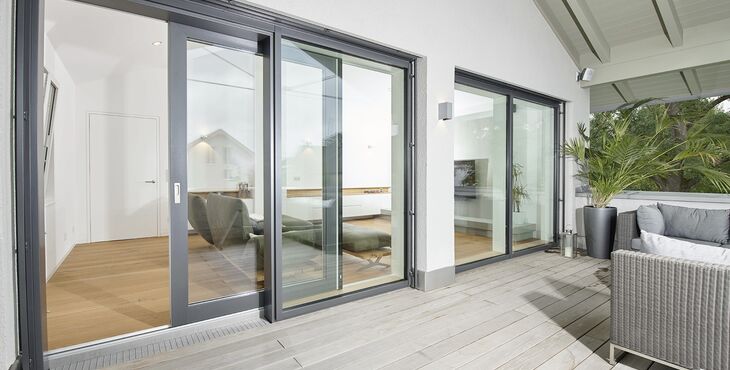 Blick vom Terrasse durch geöffnete UNILUX Kunststoff-Alu Hebe-Schiebe Anlage in modernen Wohnraum
