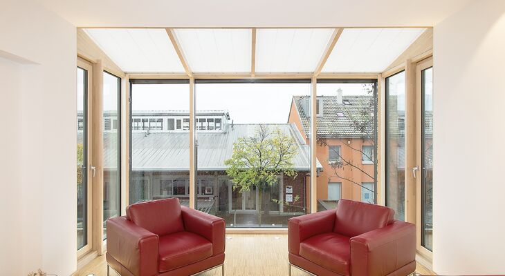 Wimnertgarten oder Balkon mit Balkontüren aus Holz in hellem Wohnbereich mit großen Holzfenstern