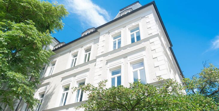 Fassade Stadtvilla mit UNILUX Holz Meisterfenster Denkmal vor blauem Himmel