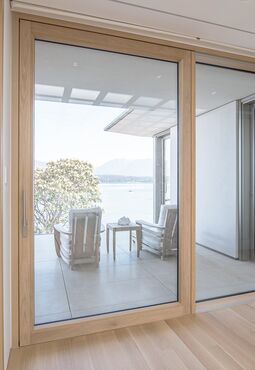 Blick aus Wohnraum auf Balkon durch geöffnete UNILUX Holz-Alu Hebe-Schiebe Anlage