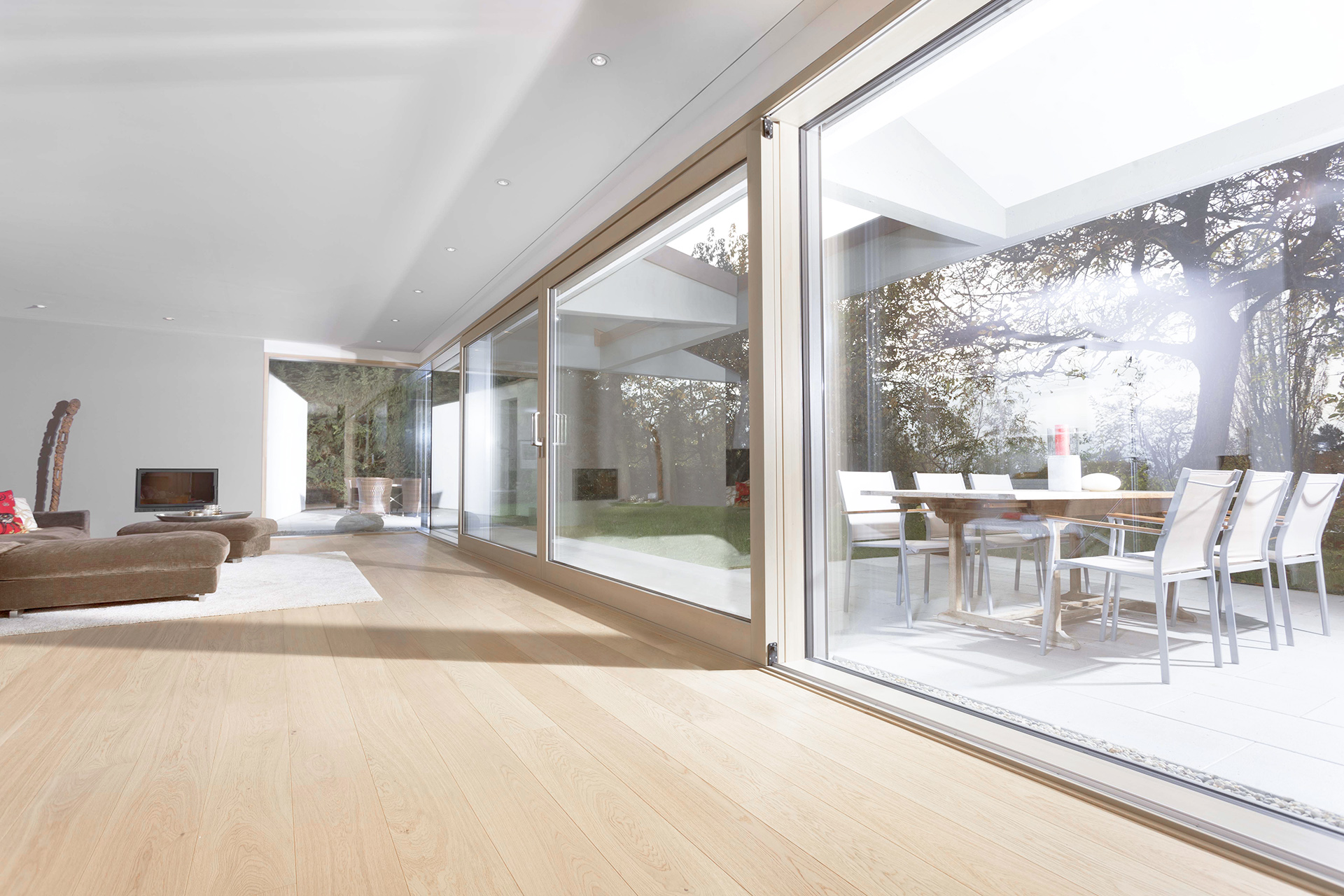 Großer moderner Wohnraum mit großer UNILUX Holz-Alu Hebe-Schiebe Anlage und Blick auf Terrasse