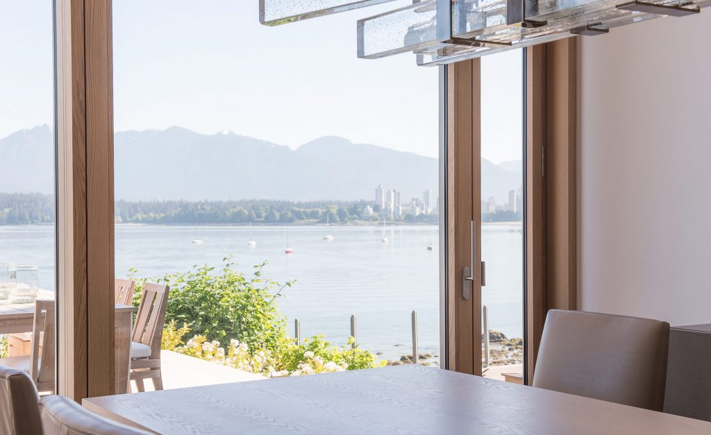 Blick auf See aus Esszimmer mit UNILUX FineLine Pfosten-Riegel-Fassade aus Holz und Alu