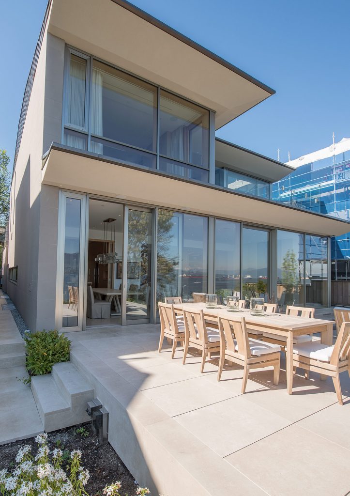 Terrasse mit modernem Wohngebäude mit UNILUX FineLine Pfosten-Riegel-Fassade aus Holz und Alu