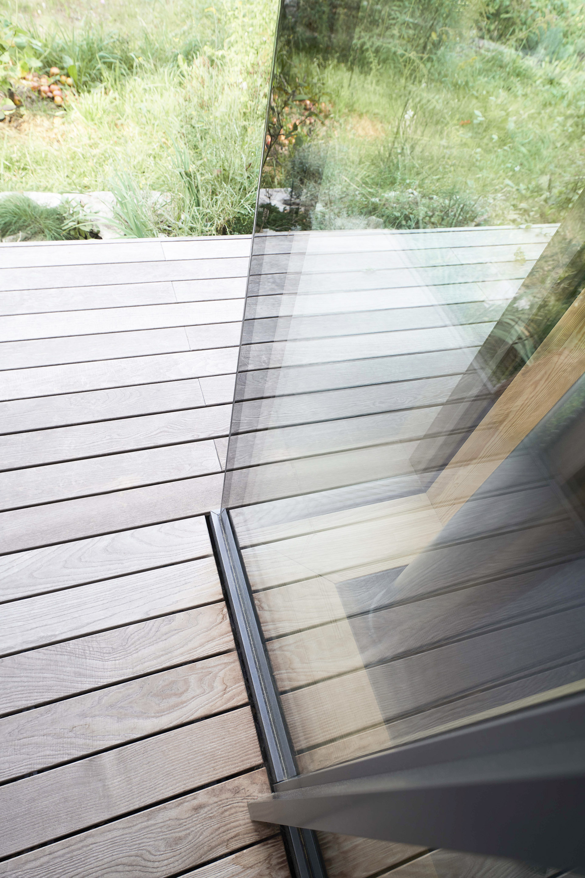 Außenansicht UNILUX Ganzglasecke OpenView bodengleiche Variante an Holzterrasse